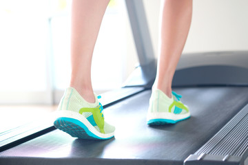 leg of woman running on treadmill in the gym which runner athletic by running shoes. Health and sport concept background,  Healthy lifestyles