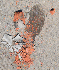 The broken bricks and pieces of slate on asphalt