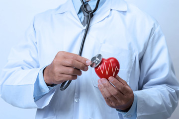 Doctor checking the red heart with stethoscope