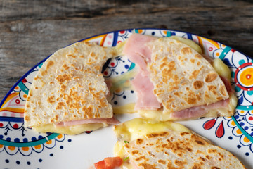 Mexican quesadillas with sliced ham also called "sincronizadas" on wooden  background