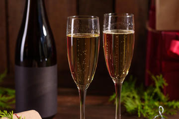 Christmas holiday table with glasses and a bottle of wine of champagne. Eve of new year, preparation and laying of a wooden holiday table