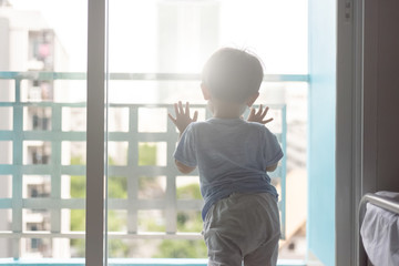 Fototapeta premium Asian young boy opening the window