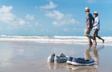 Shoe on sand of couple senior elder retire resting relax walking runing at sunset beach honeymoon family together happiness people lifestyle