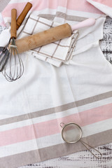 Old vintage kitchen utensils, cotton dishcloth on old white wooden background.