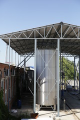 Obraz premium shiny tanks or barrels at a beer and wine factory. Industry Brewing and winemaking. Equipment for the winery and brewing