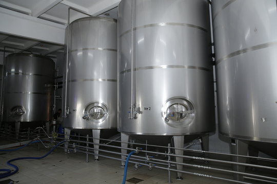 shiny tanks or barrels at a beer and wine factory. Industry Brewing and winemaking. Equipment for the winery and brewing