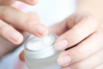 hands of a beautiful woman Dropping serum collagen moisturizer of face into clear yellow bottle soft light background. Protector skin Treatment facial essence oil, Vitamin C. Beauty and spa Con