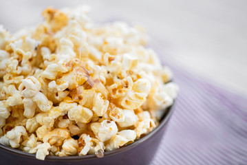 popcorn in a purple Cup on a light background