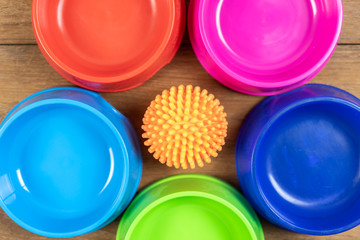 Toy and Plastic bowl on wooden table for pets.  Object for dog or cat concept
