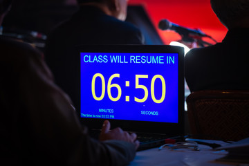 timekeeper in dark seminar room
