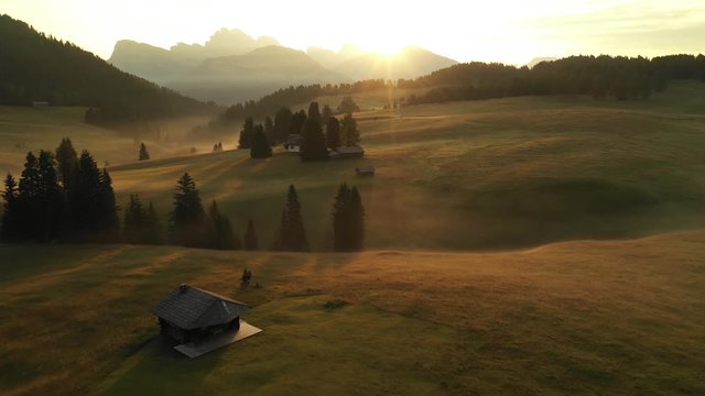 Aerial video of the sunrise in the Dolomites mountains. It was shot on the beautiful meadows of Seiser Alm plateau.