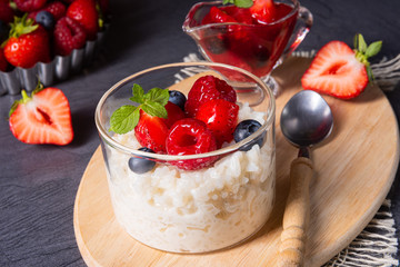 delicious milk rice with different berries and red fruit jelly