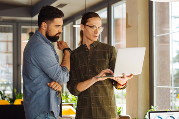 Thoughtful bearded man listening to his colleague