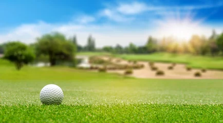Foto auf Acrylglas Weißer Golfball auf grünem Kurs, der in heller Tageszeit mit Kopienraum auf unscharfer, schöner Landschaft des Golfplatzes geschossen werden soll. Sport, Erholung, Entspannung im Urlaubskonzept © Nischaporn