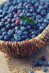 fresh blueberries in a basket on wooden surface