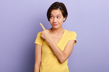 Smiling happy woman pointing finger on copy space. isolated portrait.copy space. advertisement, sale, discount, direction