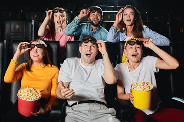 young people cheering up and laughing at funny comedy in cinema. Concept of happiness and funny...