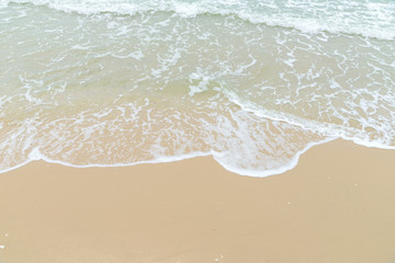 Fototapeta na wymiar Soft wave at the sea on the sandy beach. Background