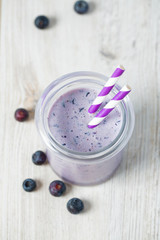 blueberry smoothie in a glass on wooden surface