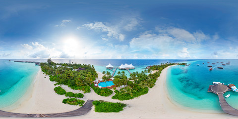 Aerial spherical panorama of tropical paradise beach  on tiny Maldives island. Turquoise ocean and white sand. Small bungalows between coconut palm trees - obrazy, fototapety, plakaty