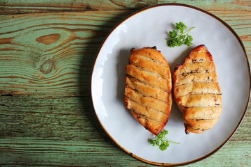 Grilled chicken breast on dark wooden background