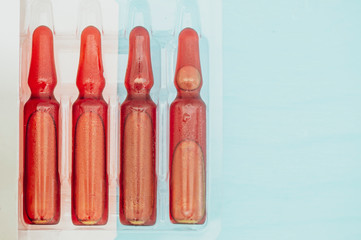 four medical ampoules, with condensation drops, selective focus tinted image, space for your text or advertising slogan