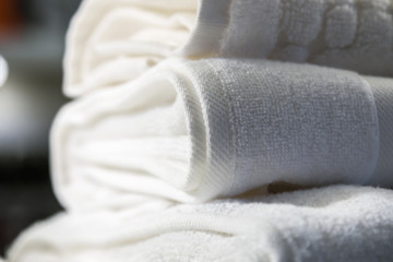 white textile towels in a stack on the shelf of a shop or production