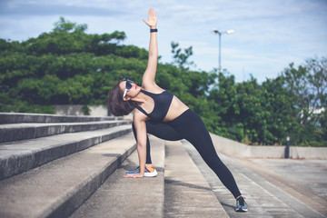 Fototapeta na wymiar Athletic woman asian warming up and Young female athlete sitting on an exercising and stretching in a park before Runner outdoors, healthy lifestyle concept