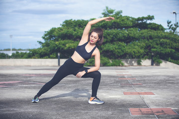 Athletic woman asian  warming up and Young female athlete sitting on an exercising and stretching...