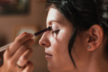Fototapeta premium Closeup Of Beautiful Young Woman Face With Beauty Makeup, Fresh Soft Skin And Long Black Thick Eyelashes Applying Mascara With Cosmetic Brush. Make-up And Cosmetics Concept. High Resolution
