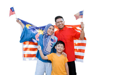 proud malaysian family holding malaysia flag in front of their house on independence day
