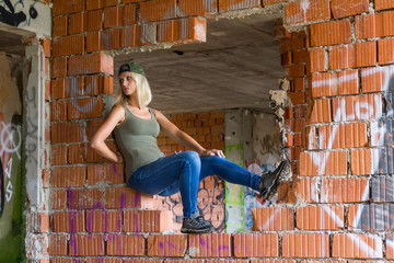CESKE BUDEJOVICE,CZECH REPUBLIC - August 19,2019 - Portrait of young woman sitting in abandoned building with graffiti