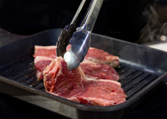 Beef fillet on grill , Beef steaks being prepared on grill , cooking meat steaks on kitchen.