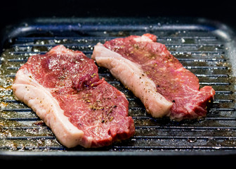 Beef fillet on grill , Beef steaks being prepared on grill , cooking meat steaks on kitchen.