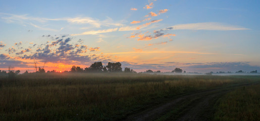 field autumn road on a beautiful foggy morning