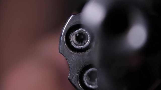 Pointing gun to camera while spinning cylinder, closeup