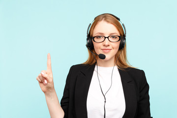 Happy female call center operator in the blue studio pointing something