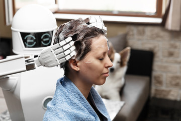 ambient assisted living household robot is washing the hair of an adult woman