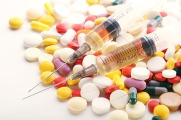 Medication pills and a sirynge as a medical healthcare concept