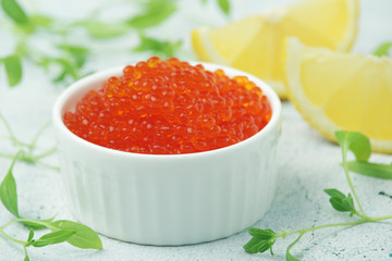 A small ceramic bowl with red caviar