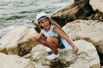 girl seashore stone is wet  spray waves