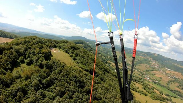Flying adrenaline adventure paragliding above green country in sunny summer