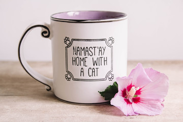 Still life of purple flower and a Cup of tea on a wooden table. Still life with tea cup
