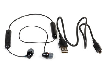 Black wireless earphones and cable on a white background