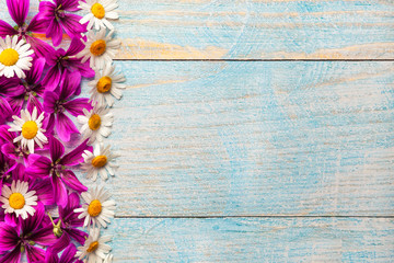 Garden purple and white flowers over blue old wooden table background with copy space.