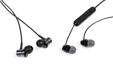 Different black in-ear earphones close-up on white background
