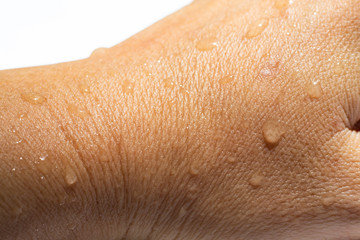 Fototapeta premium Woman's wet back hand with water drops on white acrylic background, Close up & Macro shot, Selective focus, Asian Body skin part, Relaxing Bath, Healthcare concept