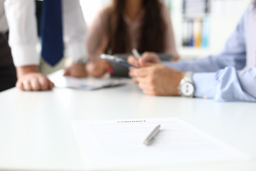 Focus on important business contract or project. Smart partners sitting in modern office and discussing significant strategy. Biz meeting concept. Blurred background