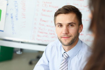 Portrait of bearded businessman sitting at workplace and looking at camera with gladness....