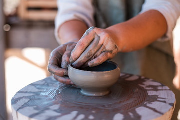 Potter is creating earthenware on potter's wheel.